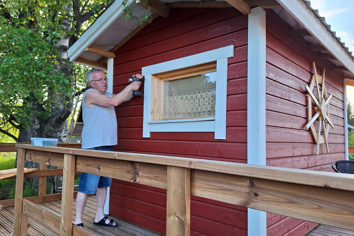 Mies ruuvaa saunalautan ikkunanpieltä.