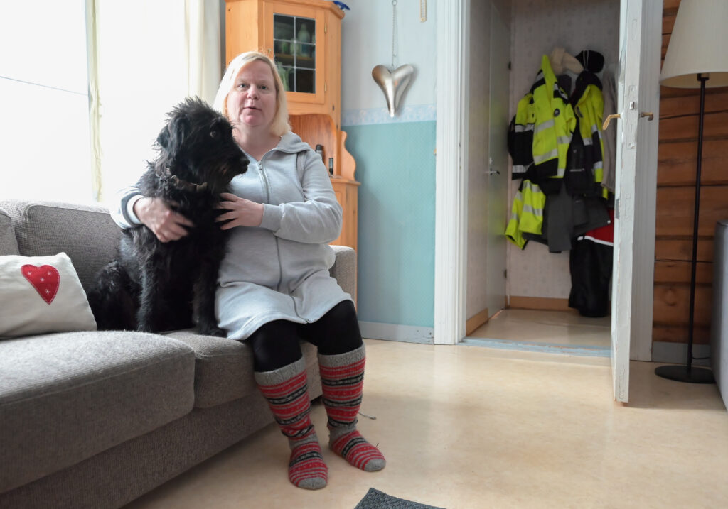 Heini Harju-Paananen ja Alma-koira istuvat sohvalla vierekkäin.