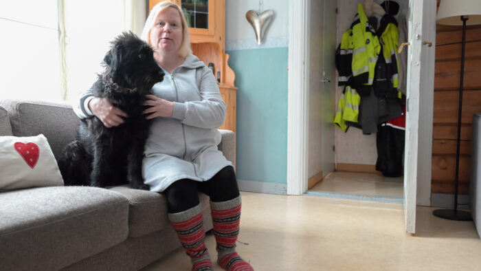 Heini Harju-Paananen ja Alma-koira istuvat sohvalla vierekkäin.