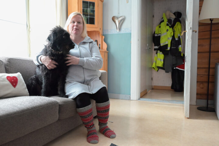 Heini Harju-Paananen ja Alma-koira istuvat sohvalla vierekkäin.