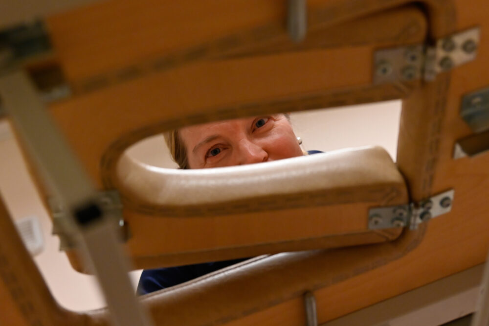 Hieroja ja yrittäjä Sirje Paukku kurkistaa hierontapöydän reiästä.