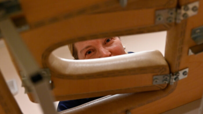 Hieroja ja yrittäjä Sirje Paukku kurkistaa hierontapöydän reiästä.